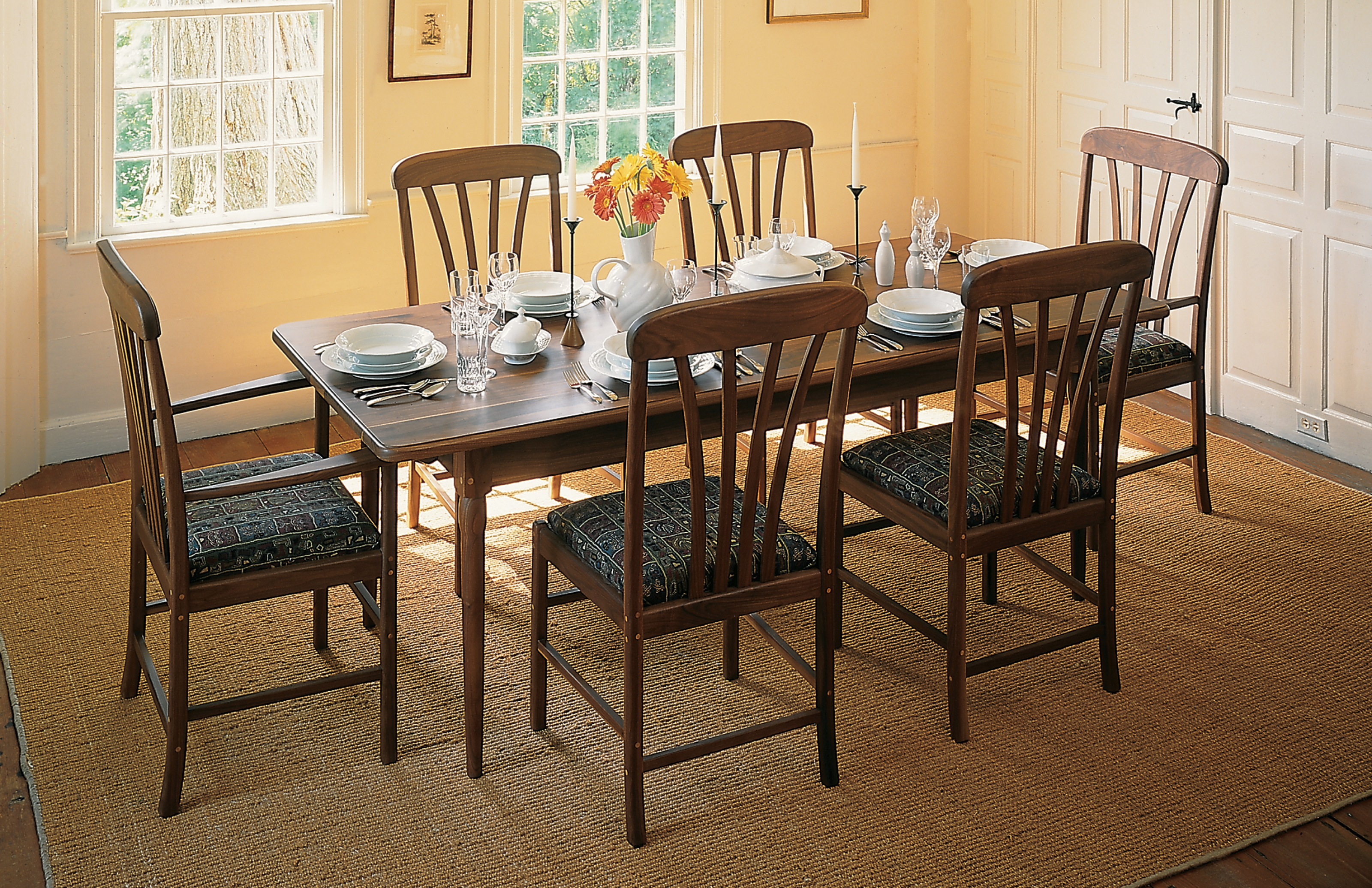 walnut dining table and chairs. Set for dinner.